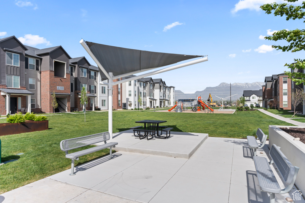 Surrounding community with a mountain view and a lawn