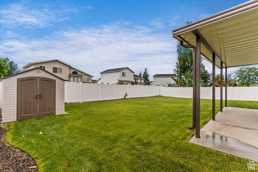 View of yard with a storage shed, a patio, and an outdoor structure