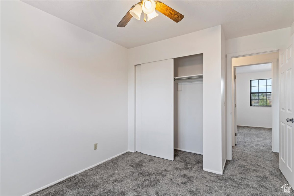 Unfurnished bedroom with carpet floors, a closet, baseboards, and ceiling fan