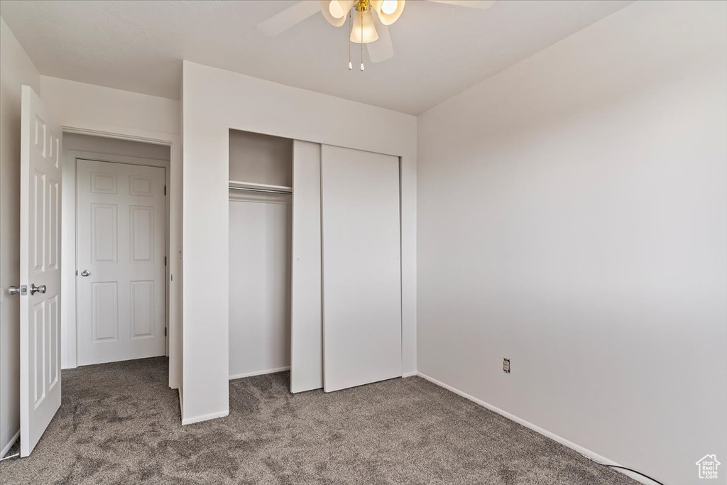 Unfurnished bedroom with carpet, baseboards, a closet, and ceiling fan