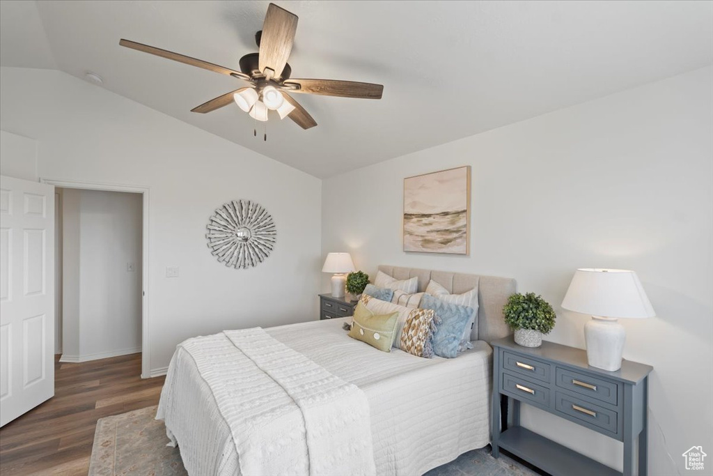 Bedroom featuring lofted ceiling, wood finished floors, a ceiling fan, and baseboards