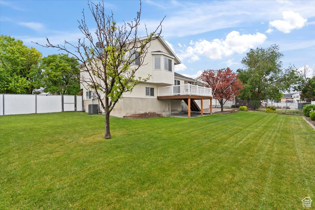 View of yard with central AC, a wooden deck, and stairs
