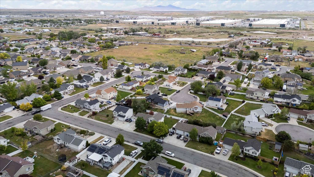 Aerial view of property and surrounding area with a mountainous background and nearby suburban area