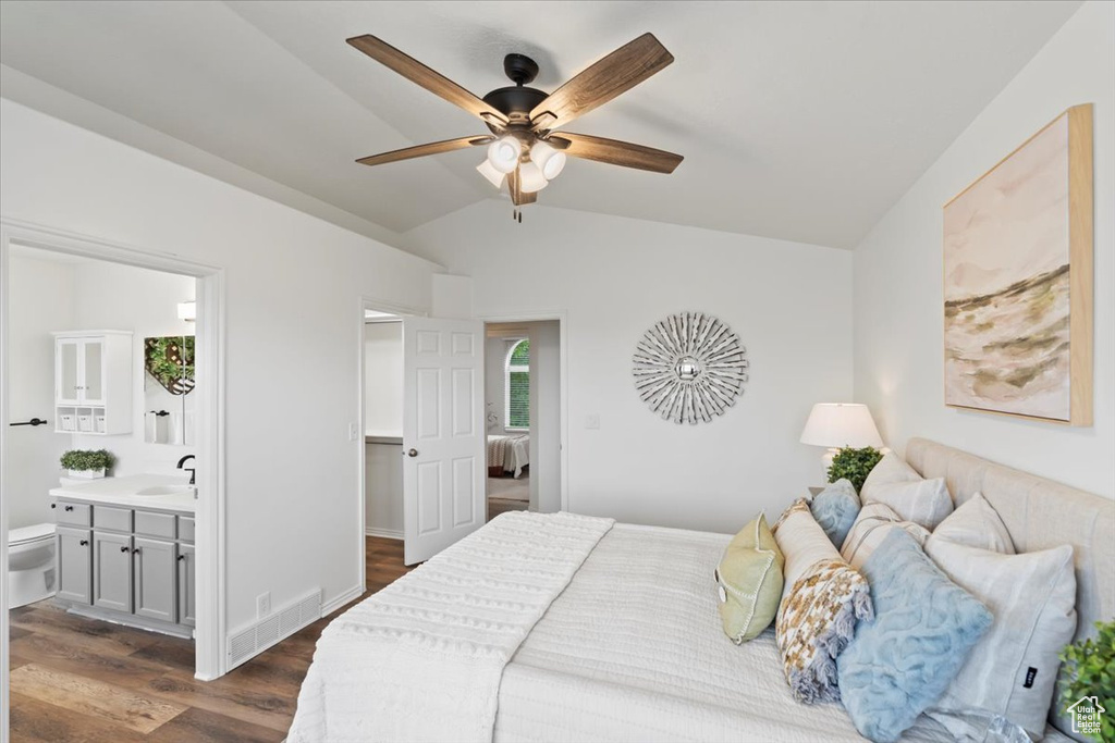 Bedroom with lofted ceiling, dark wood-type flooring, a sink, ensuite bath, and a ceiling fan