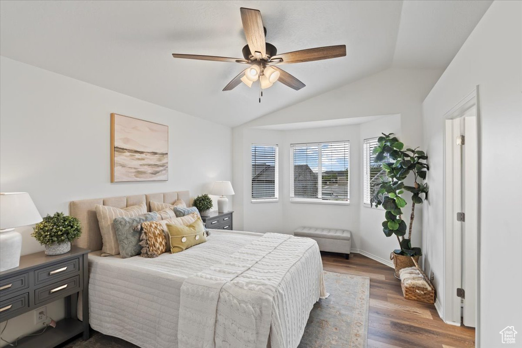 Bedroom featuring vaulted ceiling, dark wood finished floors, a ceiling fan, and baseboards