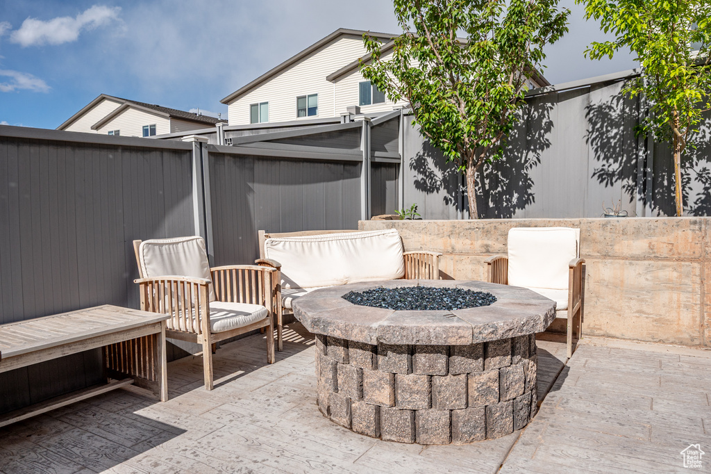 View of patio / terrace featuring an outdoor fire pit and fence