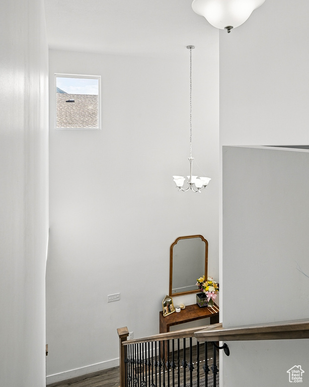 Stairs featuring a chandelier and wood finished floors