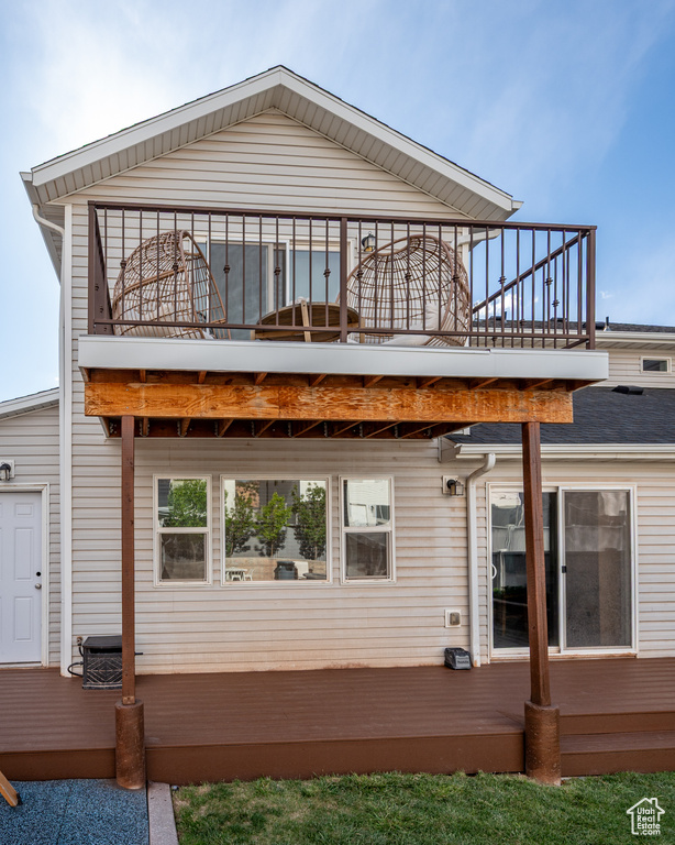 Rear view of house with a balcony and a wooden deck