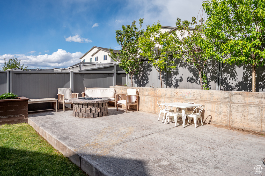View of patio featuring a fire pit and fence