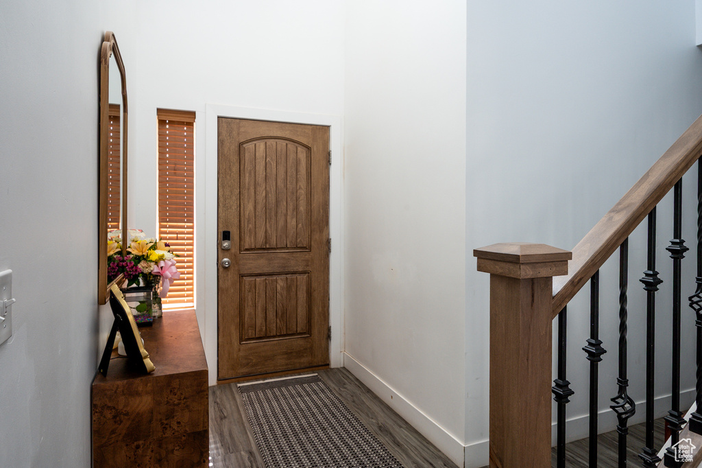Entryway featuring wood finished floors, baseboards, and stairs