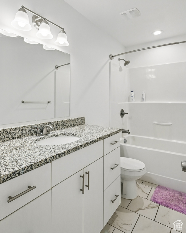 Bathroom featuring marble finish floors, vanity, toilet, and bathing tub / shower combination