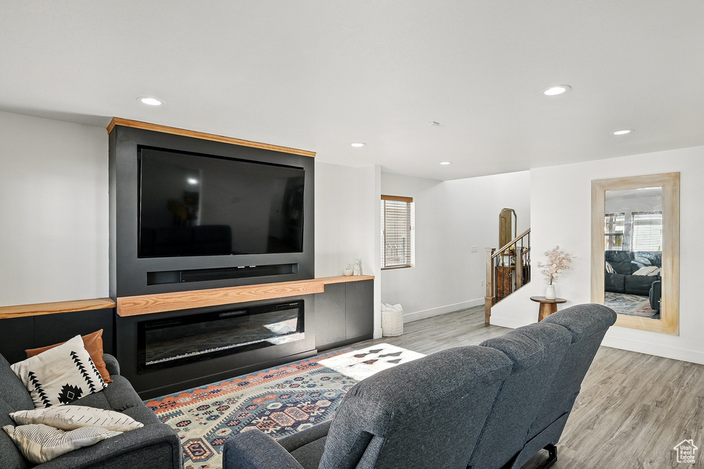 Living area with stairs, recessed lighting, wood finished floors, and baseboards