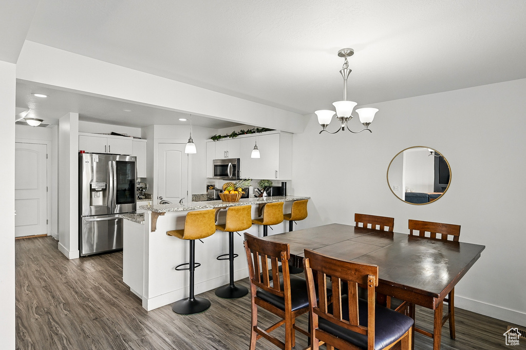 Dining area featuring a chandelier, dark wood-style floors, baseboards, and recessed lighting