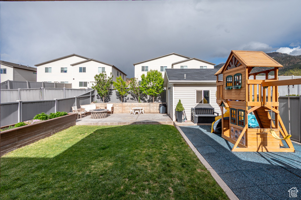 View of yard featuring a playground, a patio, and a fire pit