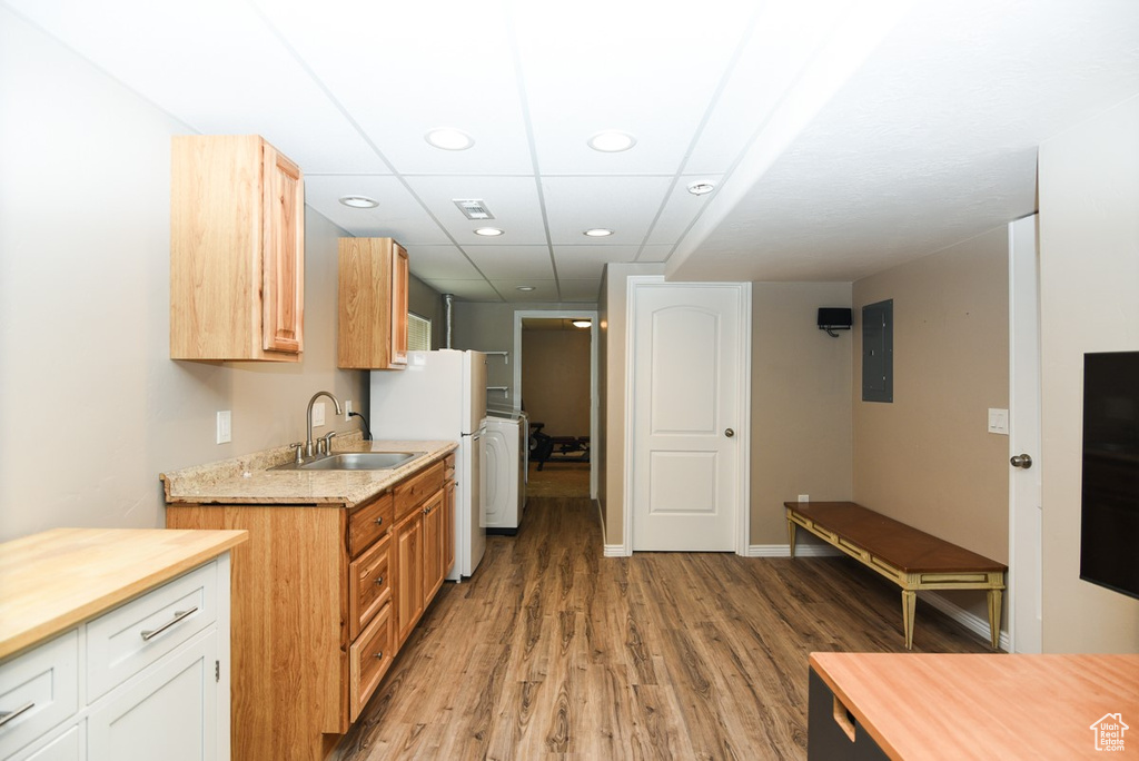 Kitchen featuring a sink, light wood-style floors, electric panel, recessed lighting, and wood counters