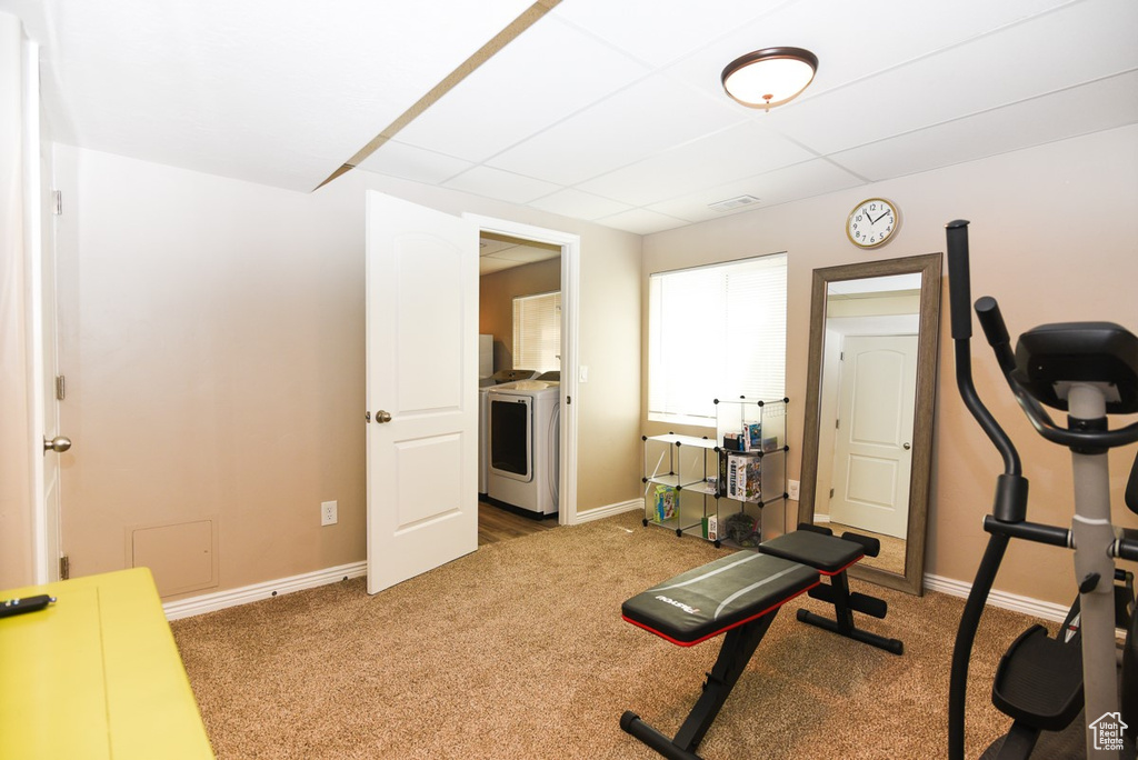 Workout room featuring washer / clothes dryer, carpet flooring, baseboards, and a drop ceiling
