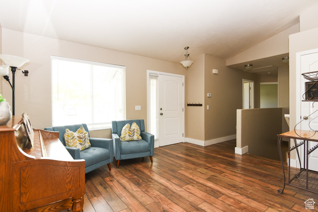 Living area with hardwood / wood-style flooring, lofted ceiling, and baseboards