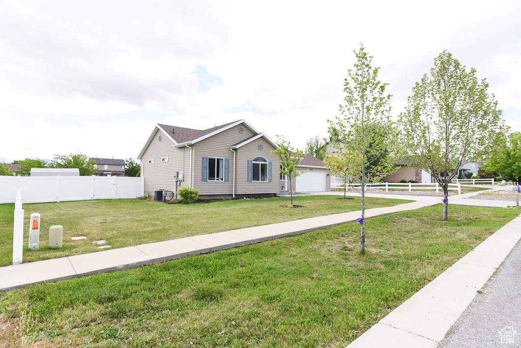 View of front of property with a garage and central air condition unit