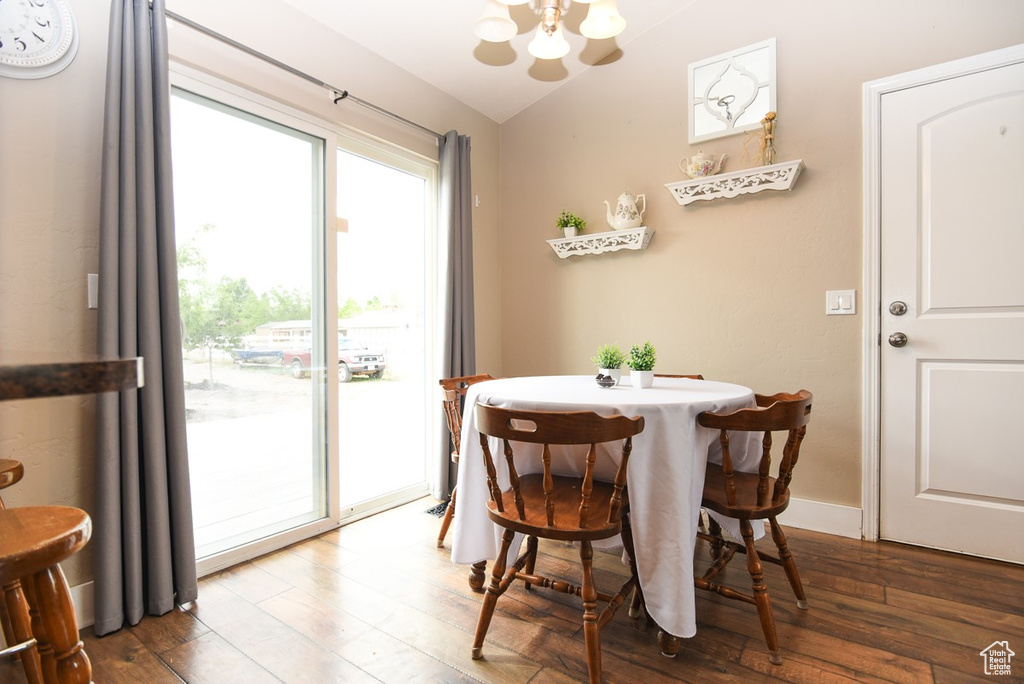 Dining area with a chandelier, hardwood / wood-style flooring, and lofted ceiling