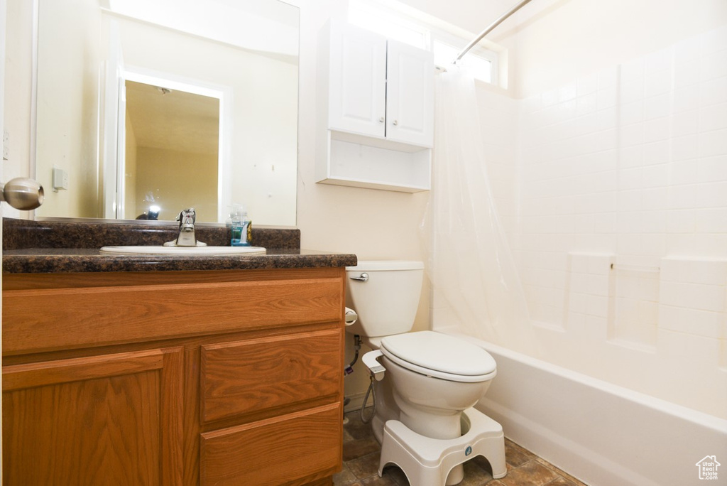 Full bath with toilet, vanity, and shower / bath combination with curtain