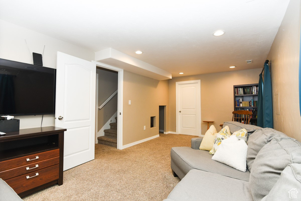 Living area featuring stairway, light carpet, recessed lighting, and baseboards