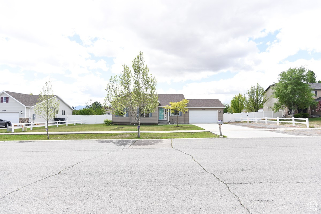 View of front of home with driveway and a garage