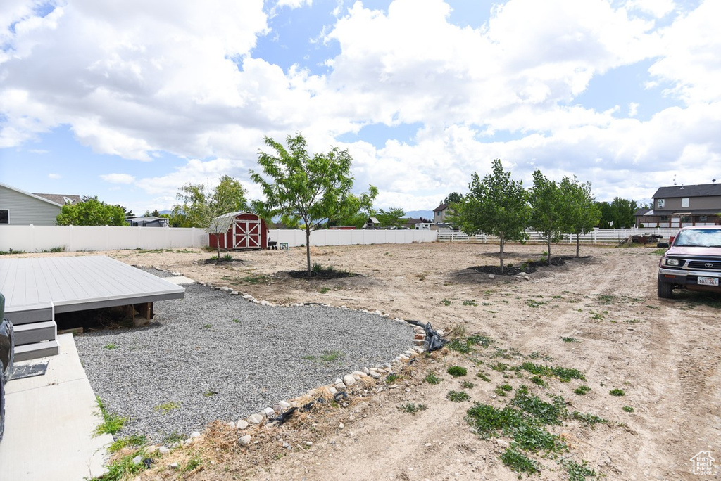 View of yard featuring fence, an outbuilding, and a storage unit