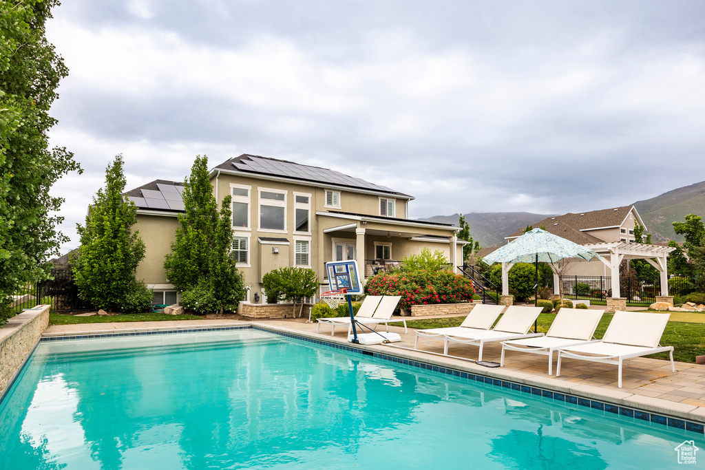 Swimming pool featuring a pergola, a patio, and fence