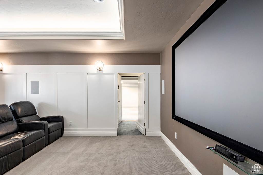 Cinema room featuring light colored carpet and a textured ceiling
