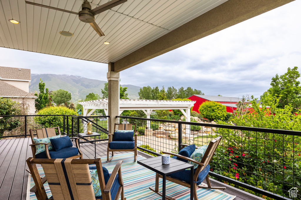 Deck with a mountain view and ceiling fan