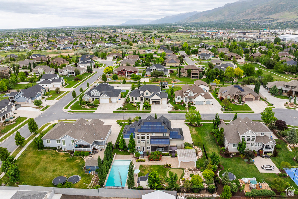 Aerial perspective of suburban area featuring a mountain backdrop and a pool