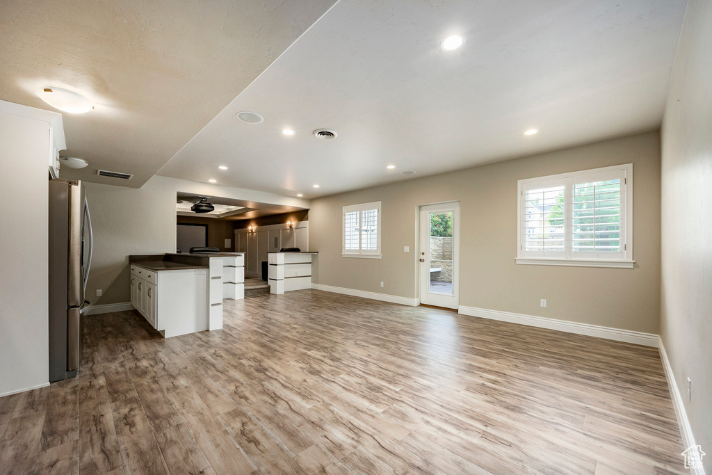 Kitchen featuring freestanding refrigerator, baseboards, open floor plan, and recessed lighting