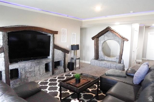 Living area featuring crown molding, baseboards, carpet, and a fireplace