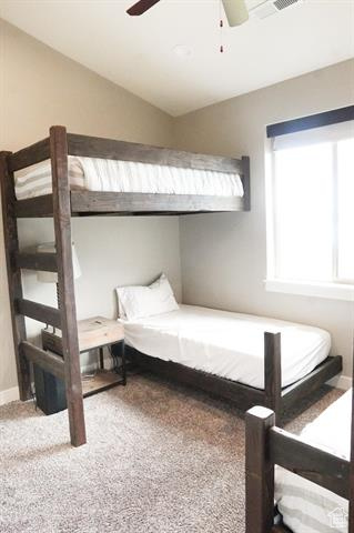 Bedroom with carpet floors, a ceiling fan, lofted ceiling, and baseboards