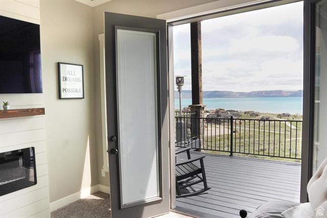Entryway featuring baseboards, a water view, and carpet floors