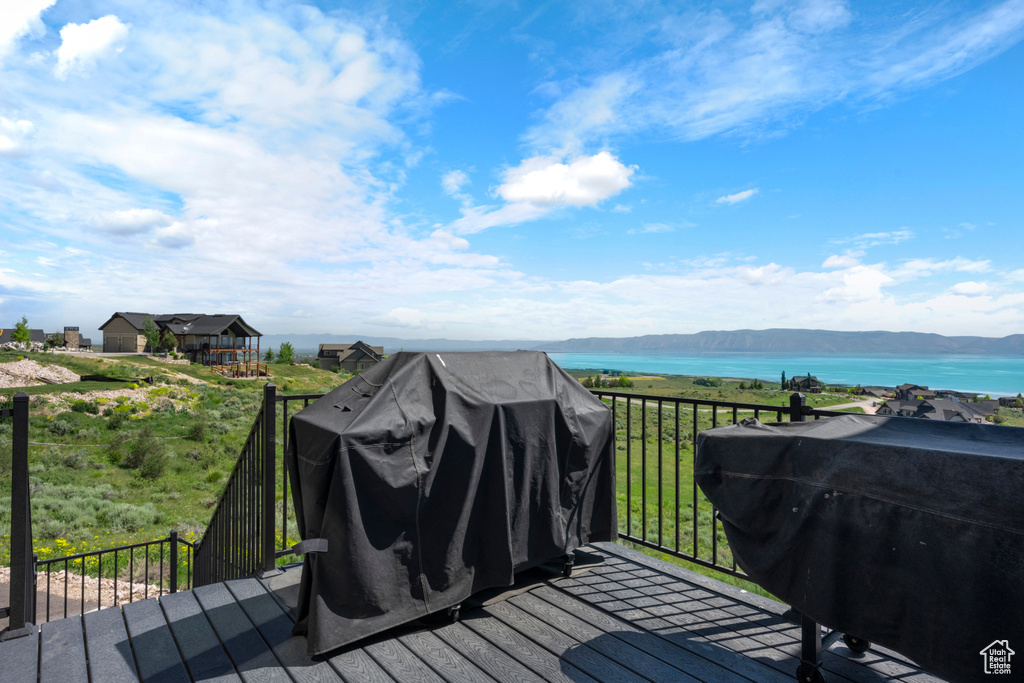 Wooden deck featuring a water and mountain view and grilling area