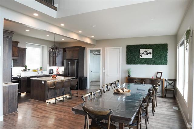 Dining space featuring healthy amount of natural light, wood finished floors, recessed lighting, and baseboards