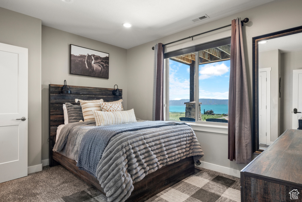 Bedroom with a water view, recessed lighting, and carpet floors