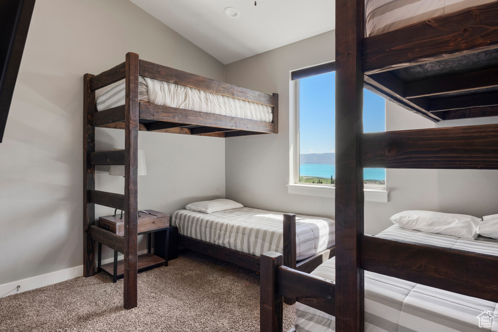 Carpeted bedroom featuring lofted ceiling and baseboards