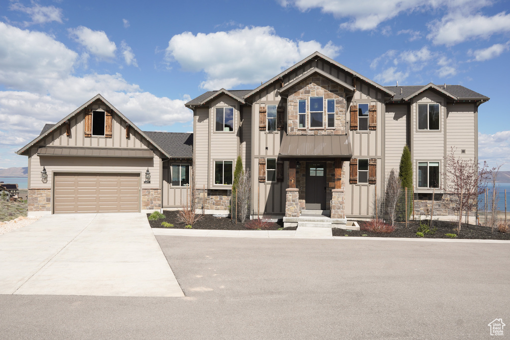 Craftsman house featuring stone siding, board and batten siding, concrete driveway, and an attached garage