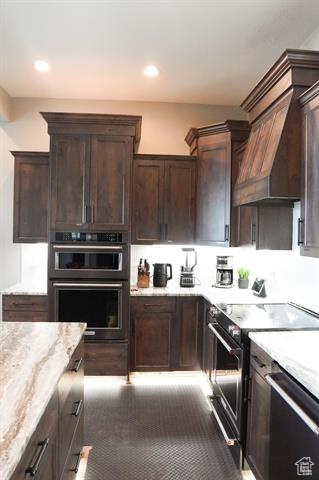 Kitchen with electric range, dishwasher, dark brown cabinetry, light stone countertops, and recessed lighting