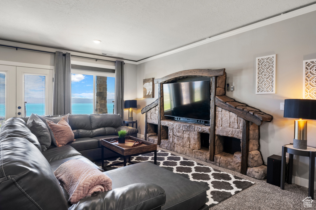 Carpeted living area featuring crown molding, french doors, and a fireplace