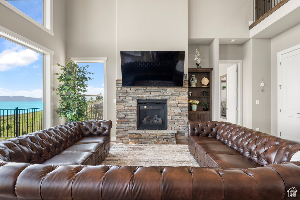Living area with a towering ceiling, a fireplace, and built in shelves