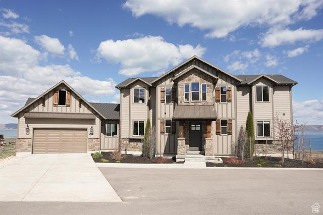 Craftsman-style house featuring stone siding, board and batten siding, concrete driveway, and an attached garage