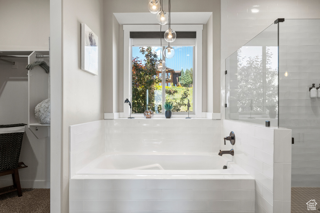 Full bath with a bath, a stall shower, and a walk in closet