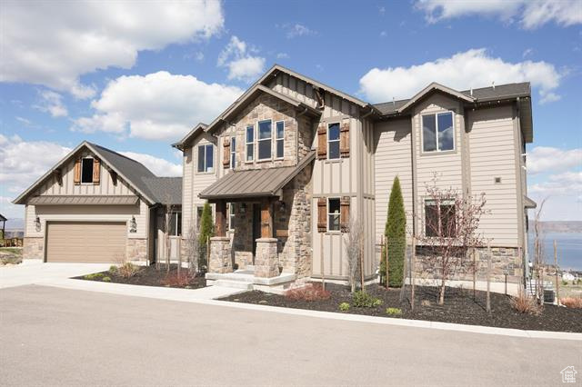 Craftsman-style house with stone siding, board and batten siding, concrete driveway, and a garage