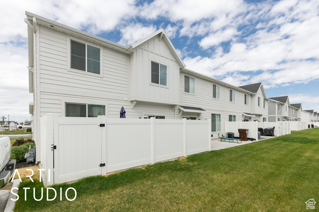 Rear view of property with board and batten siding, a patio area, and a residential view