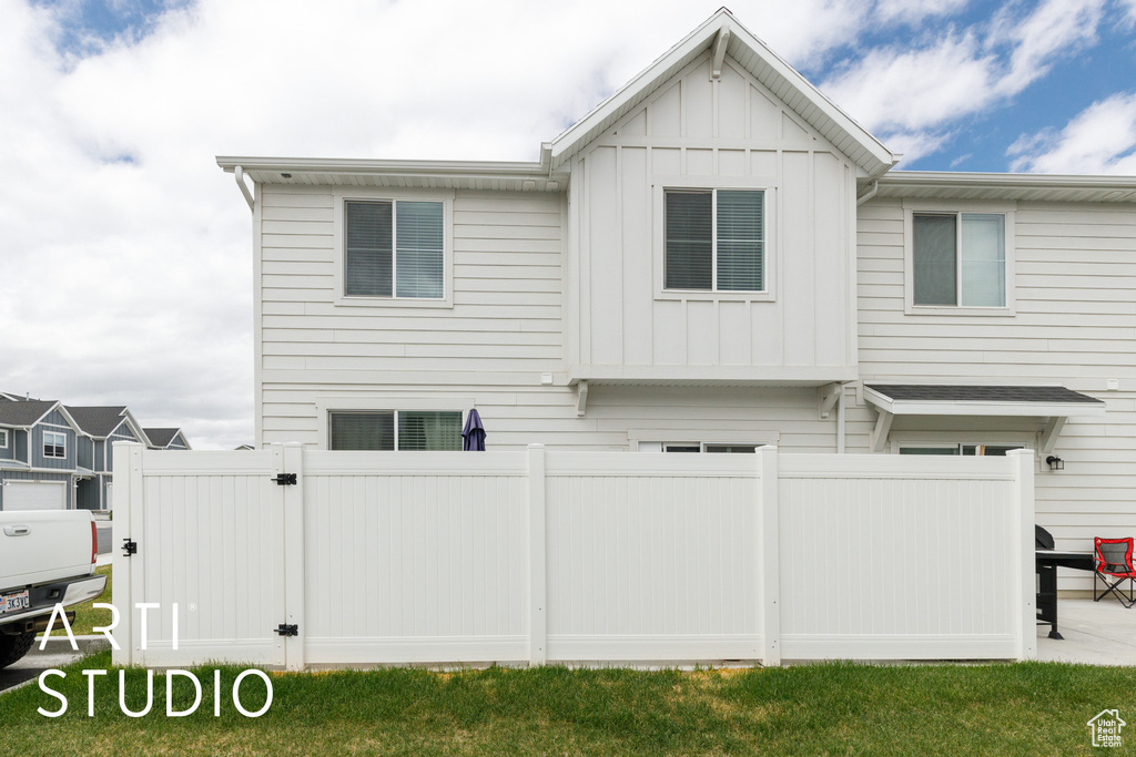 Back of property featuring board and batten siding and fence