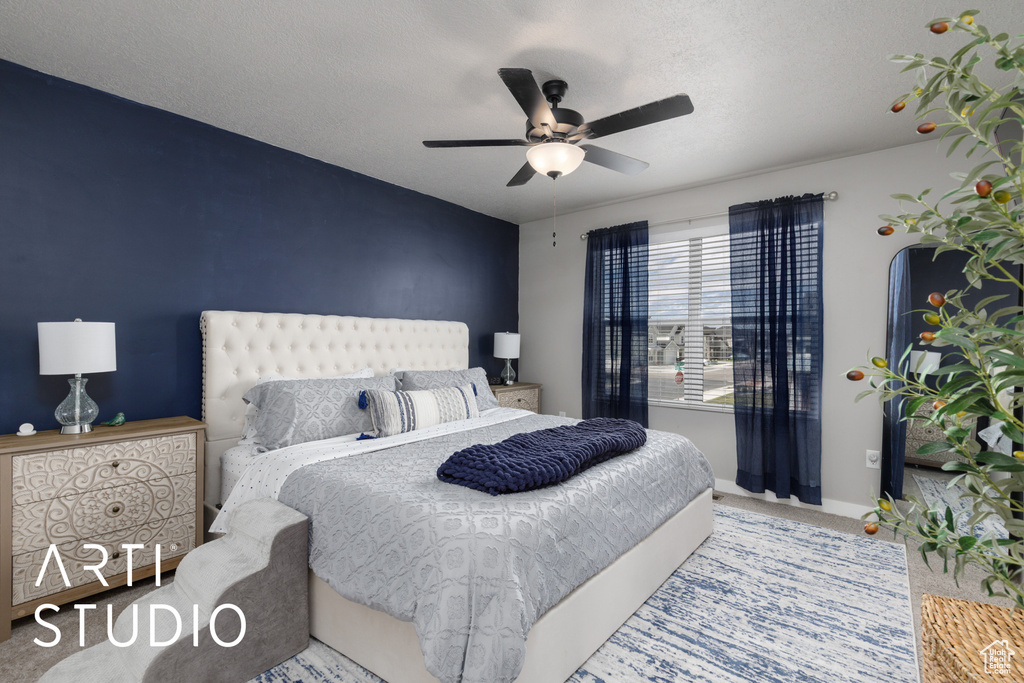 Carpeted bedroom with ceiling fan and baseboards