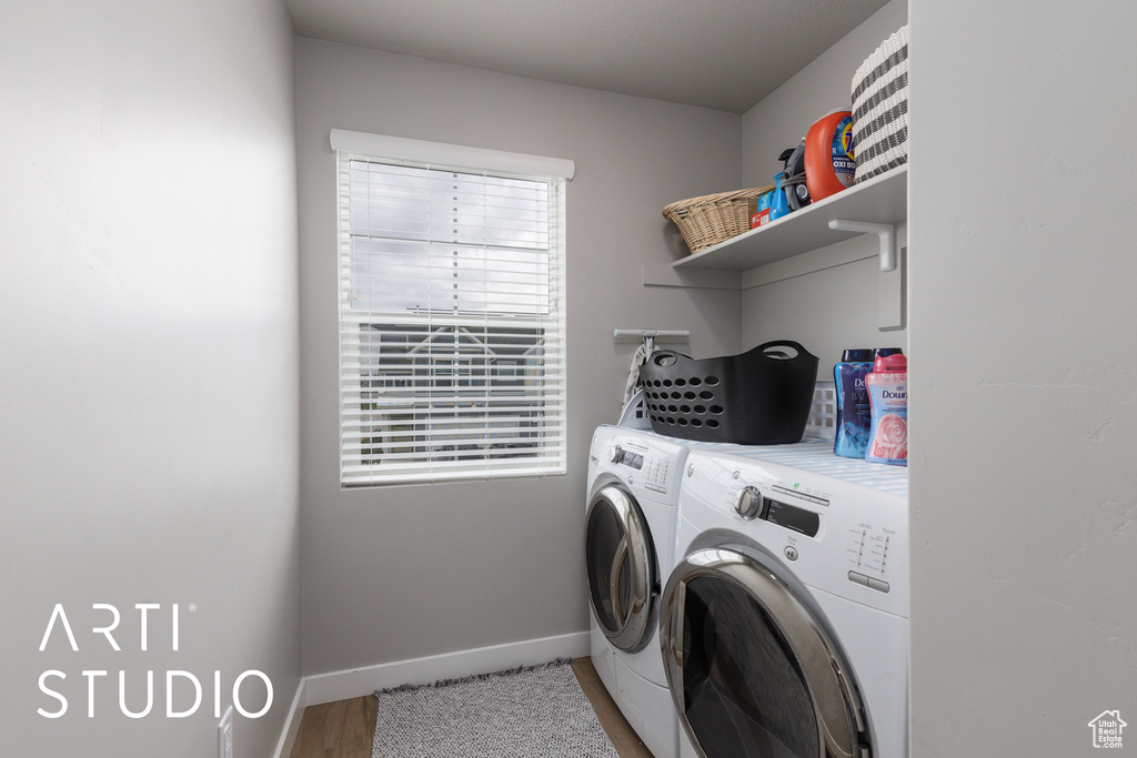 Washroom with washer and clothes dryer, baseboards, and light wood-type flooring